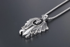 Close-up of punk style skull wing pendant in polished steel with box chain detail