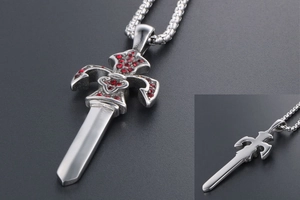 Macro detail of sword pendant showing silver metal patterns and inlaid red rhinestones