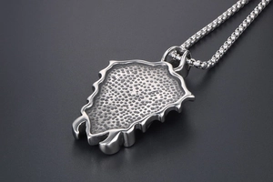 Macro shot of silver punk skull sword pendant with honeycomb hammered texture detail