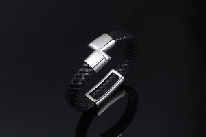 Detailed view of woven black leather bracelet with polished silver metal clasp
