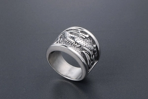 Vue macro d'une bague en titane argenté poli avec des écailles et des motifs de dragon