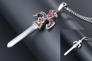 Macro shot of silver gothic sword pendant with red crystal inlay and fleur-de-lis guard