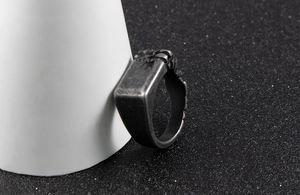 Detail view of vintage stainless steel signet ring with embossed relief wing texture