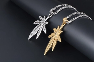 Détail des pendentifs feuille d'érable en or et argent avec motifs étoilés gravés fins