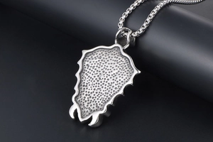 Macro shot of punk shield pendant with textured dots and durable box chain link