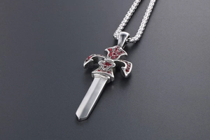 Detailed close-up of a silver sword pendant with red zircons and gothic fleur-de-lis
