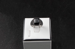 Vue macro d'une bague vintage pour homme en acier avec une pierre noire rectangulaire