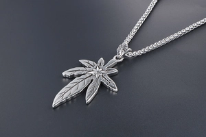 Gros plan d'un pendentif feuille d'érable argentée avec relief d'étoile et chaîne box