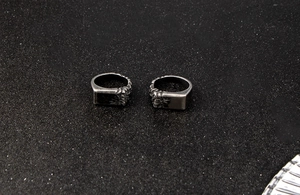 Detail view of vintage square-faced stainless steel ring with side flame engravings