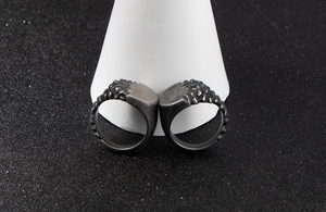 Close-up of vintage stainless steel rings with gravel texture and gothic armor pattern