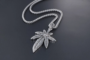 Vue détaillée du pendentif feuille d'érable et de la chaîne à maillons texturés