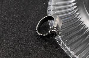 Macro detail of men's vintage steel ring with rugged rock texture and matte finish