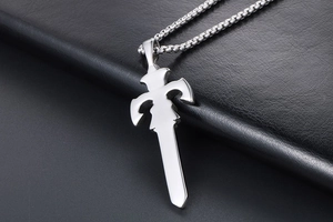 Macro shot of silver sword pendant with box chain on black leather background