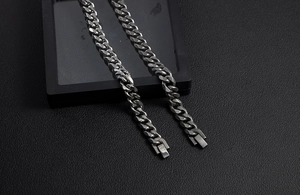 Close-up of high-polished stainless steel Cuban link bracelets on a black background