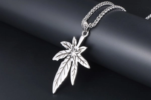 Détail macro d'un pendentif feuille d'érable en acier titane vintage aux nervures fines