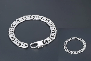 Gros plan du bracelet à maillons entrelacés argentés avec fermoir mousqueton et fini brillant