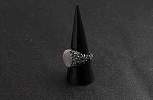 Detailed view of men's vintage stainless steel ring with brushed and scaly metal textures