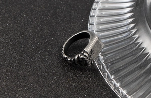 Detail view of vintage stainless steel signet ring with side claw texture and gray finish
