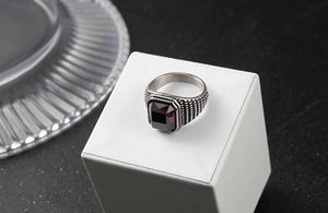 Détail d'une bague vintage pour homme en acier avec un zircon rouge de forme rectangle