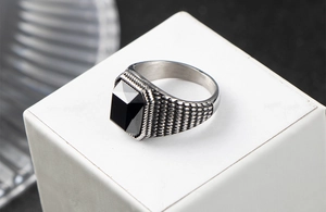 Macro d'une bague vintage pour homme avec pierre noire rectangulaire et anneau sculpté