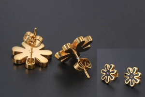 Detailed view of daisy-shaped gold-plated steel stud earrings with black enamel inlay