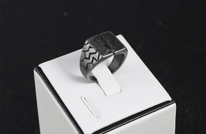 Macro shot of men's vintage titanium steel ring with dark geometric crack patterns