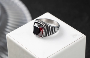Détail d'une bague vintage pour hommes en acier inoxydable avec un rubis zircon rouge carré