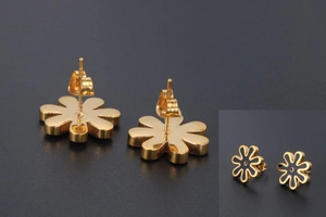 Detail view of gold-plated daisy stud earrings with black enamel floral design