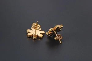 Close-up of golden daisy stud earrings with flower shape and butterfly back closure
