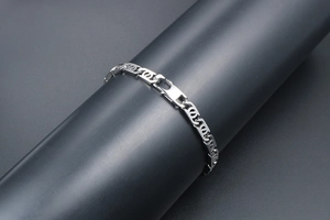 Close-up of geometric links on a silver stainless steel bracelet with lobster clasp