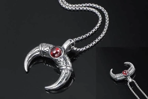 Macro detail of horn pendant with red gemstone and vintage pattern on box chain