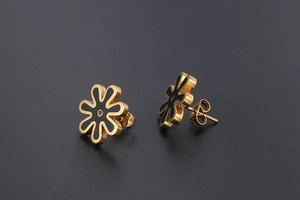 Detailed close-up of gold-plated daisy stud earrings with black enamel and red stone