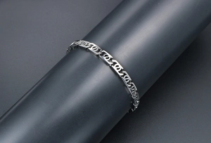 Detailed view of silver titanium steel chain bracelet with GG logo links on display