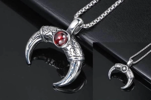 Macro detail of horn-shaped titanium steel pendant with carved patterns and red gemstone