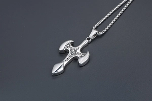 Close-up of titanium steel cross pendant with vintage floral engravings and box chain