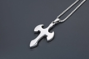Detail of silver cross pendant with curved edges and box chain in gothic style