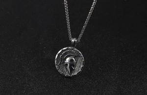 Détail macro d'un pendentif rétro en acier inoxydable avec casque spartiate gravé