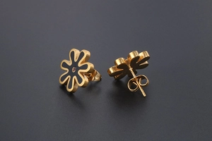 Macro shot of gold daisy studs with black petals and red rhinestone center detail