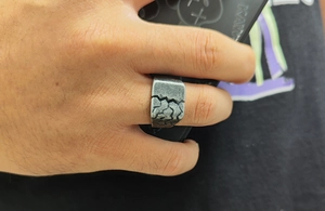 Macro shot of retro titanium steel ring featuring a vintage cracked rock pattern on band