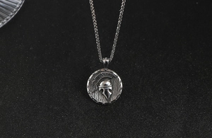 Détail macro du pendentif casque spartiate vintage en acier titane avec chaîne tressée