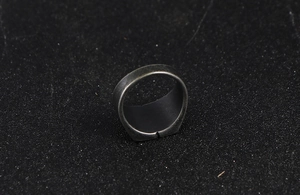 Detail of vintage cracked texture on wide dark silver titanium steel adjustable ring