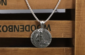 Macro detail of retro silver Spartan warrior pendant with Greek key pattern and braided chain
