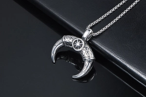 Detailed close-up of retro silver bull horn pendant with ruby star and cloud patterns