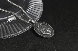 Détail macro du relief couronne d'épines et main au clou sur pendentif en acier rétro