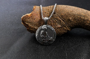 Close-up of Spartan warrior pendant hanging on weathered wood with Greek meander detail