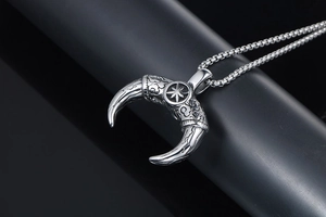 Macro detail of tribal bull horn pendant with star pattern and durable steel box chain
