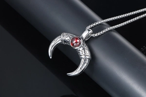 Macro detail of men's horn pendant with red gemstone and antique cloud patterns