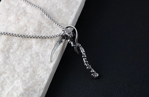 Detailed close-up of retro silver Grim Reaper scythe pendant with vintage steel finish