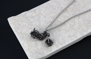 Detailed macro view of a vintage motorcycle pendant with intricate mechanical engine carvings