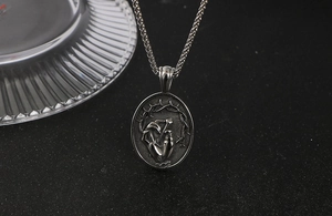 Détail du pendentif vintage en acier titane avec couronne d'épines et clou percé